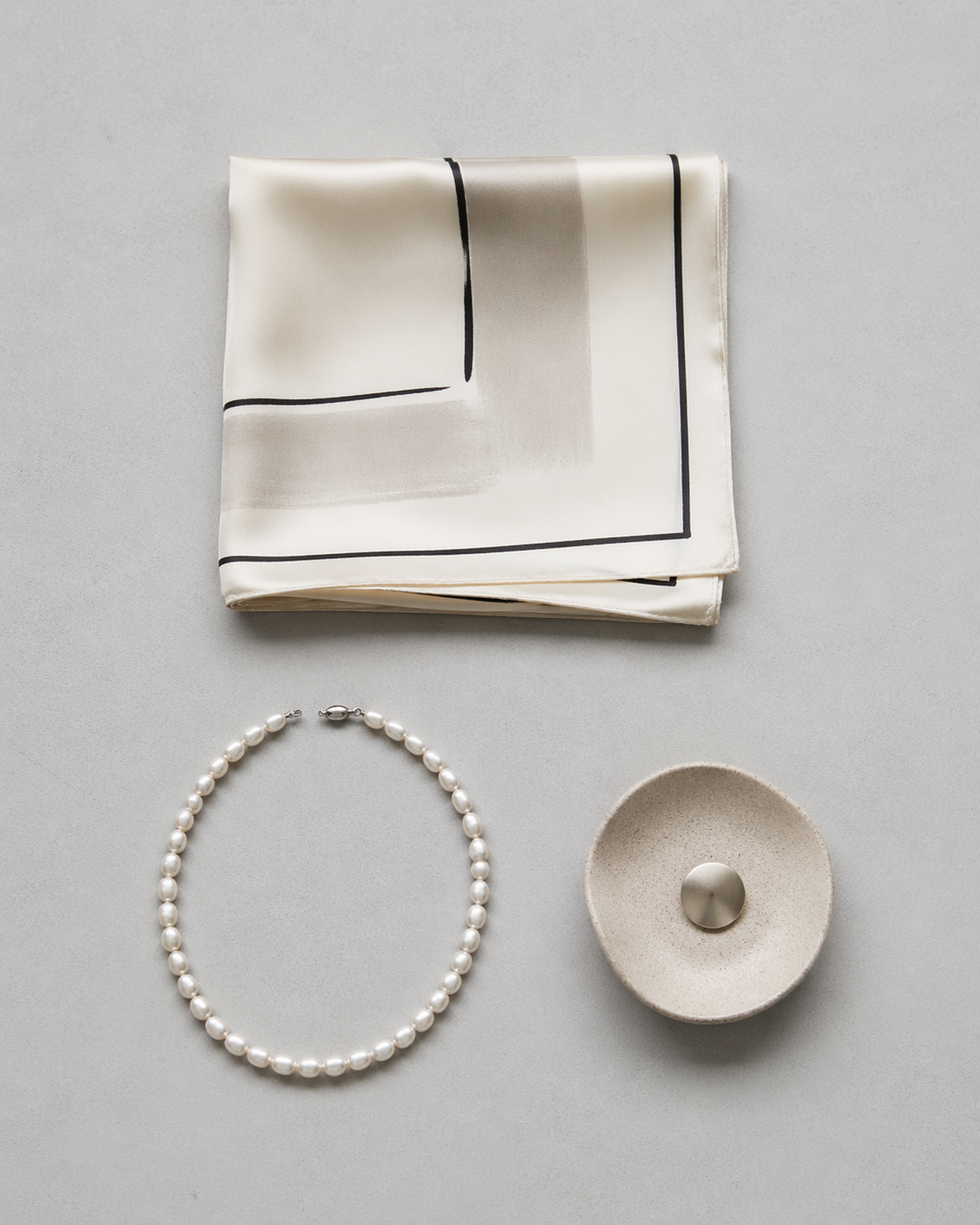 Curator's composition — scarf, pearls, brass key, ceramic dish