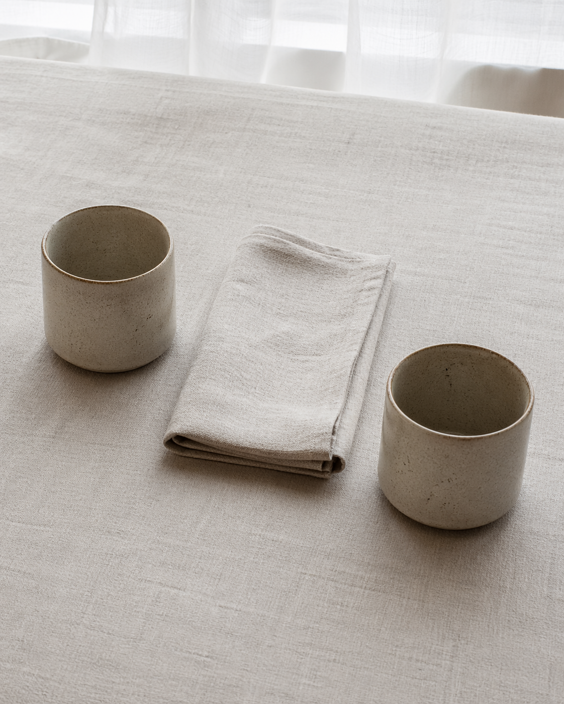Two teacups on a marble side-table in warm afternoon light